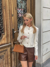A blonde woman wears a chenille jacket